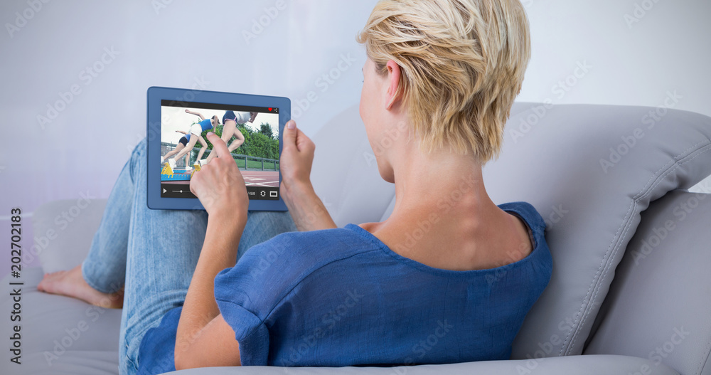 金发女子在沙发上使用平板电脑对抗女性起跑