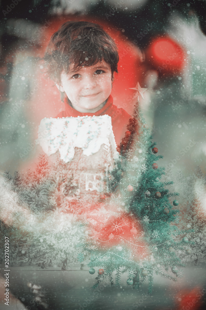 雪地里，一个喜庆的小男孩拿着姜饼屋对着圣诞树