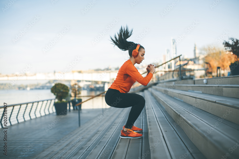 Woman with headphone exercising by river 