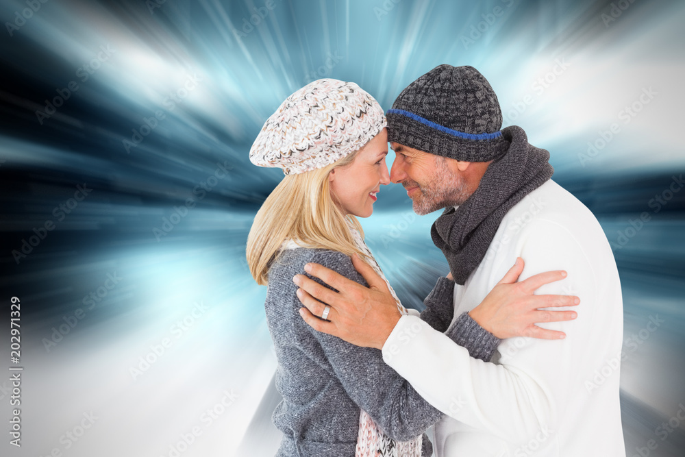 幸福的情侣在冬季时尚中拥抱在俯瞰雪天的大岩石上