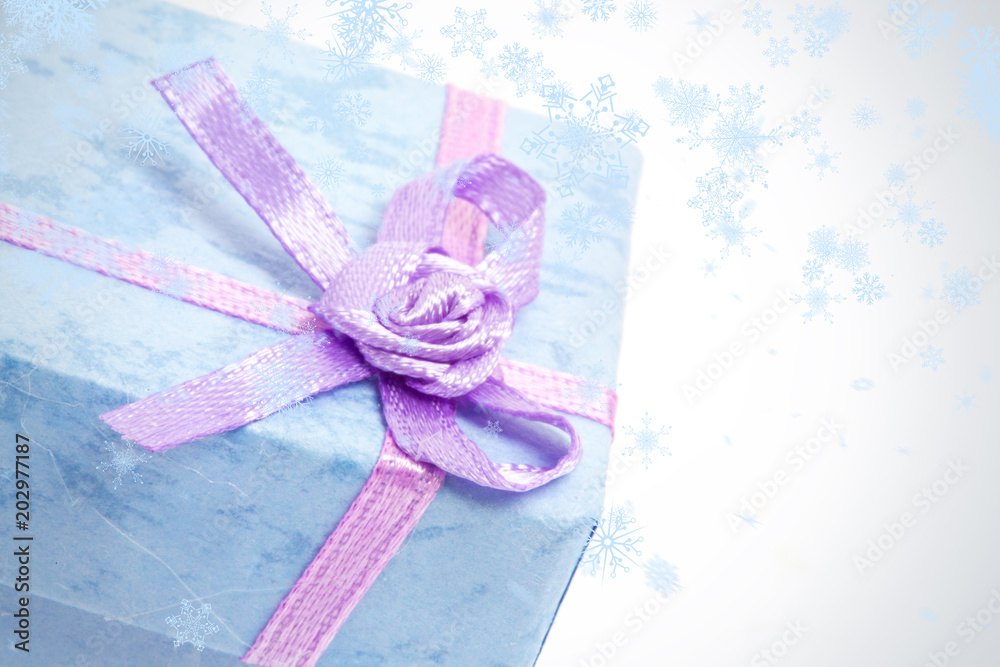 雪花飘落在紫色缎带蓝色礼盒的特写镜头上
