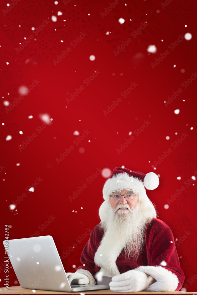 圣诞老人在红色雪花背景下用笔记本电脑上的信用卡付款