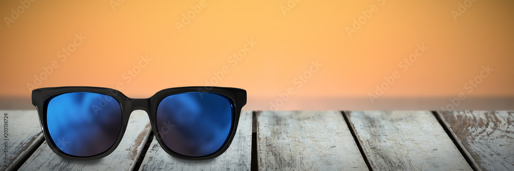太阳眼镜在日落时抵御海浪的特写