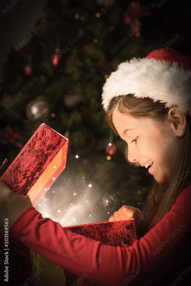小女孩在雪地里打开一份神奇的圣诞礼物