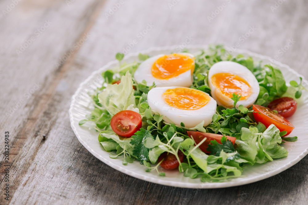 营养蔬菜沙拉配水煮蛋片，装在T形白盘子里的高角度视图