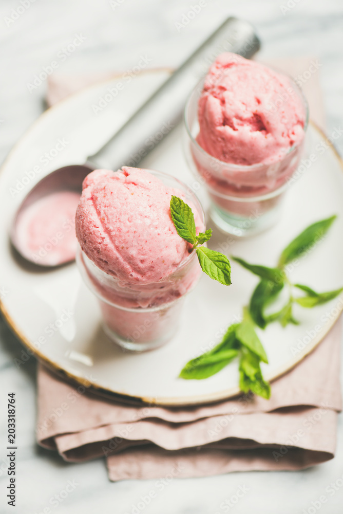 健康的低热量夏季甜点。浅灰色玻璃杯自制草莓酸奶冰淇淋