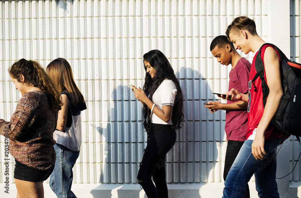 一群青少年朋友放学后使用智能手机成瘾概念回家