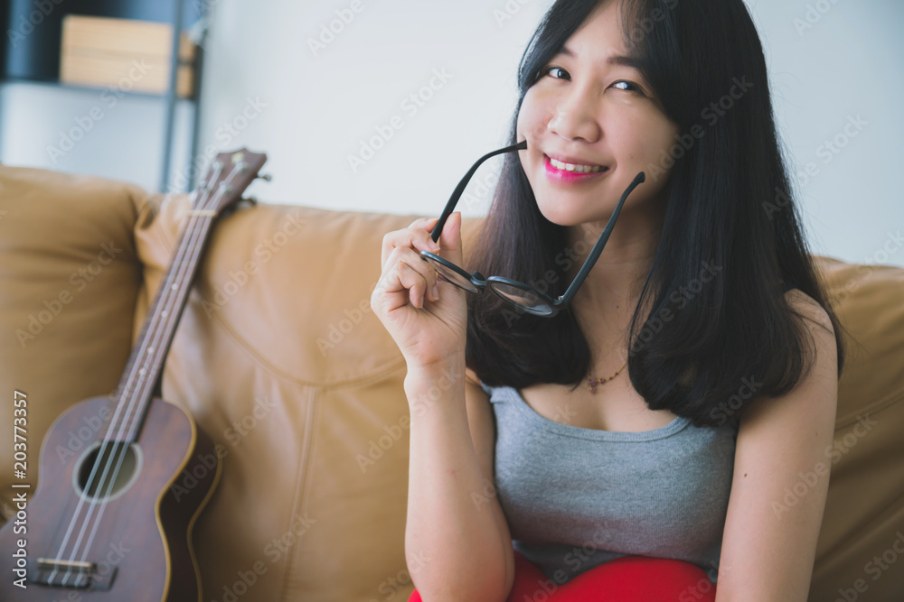 业余音乐ukelele与穿着黄色衬衫的亚洲美女一起快乐地唱歌和演奏u