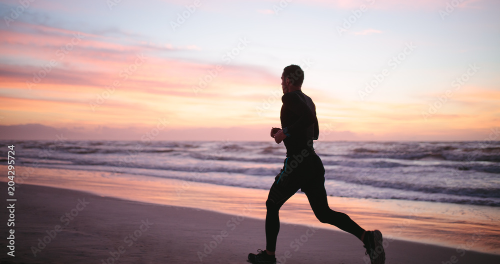 健康的男人沿着海岸慢跑