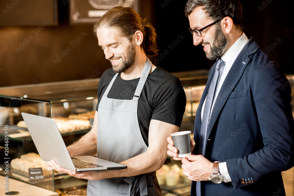 Businessman and barista working in the pastry shop