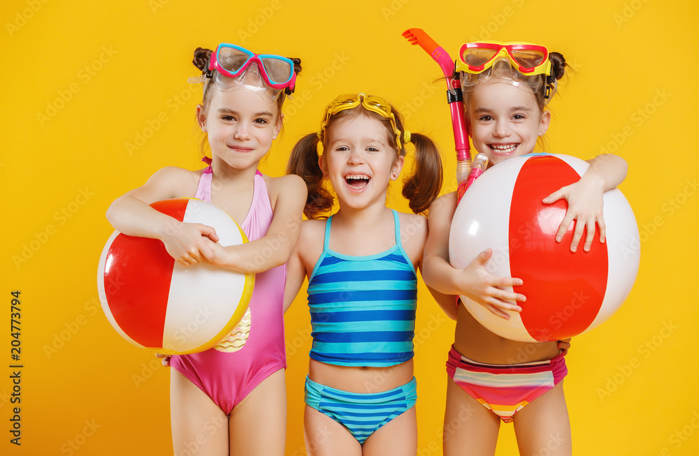 有趣有趣快乐的孩子穿着泳衣在彩色背景上跳跃