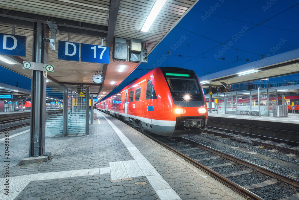 High speed train on the railway station at night in Nuremberg, Germany. Modern intercity train on th