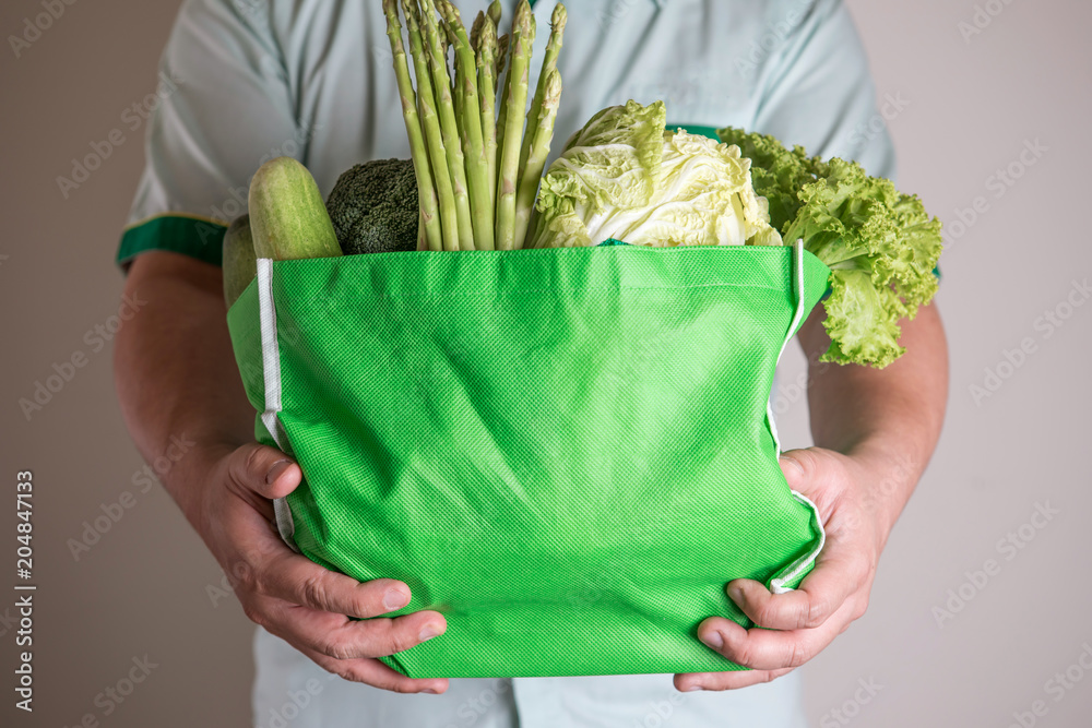 近距离手持混合有机绿色蔬菜的绿色食品袋，健康有机蔬菜