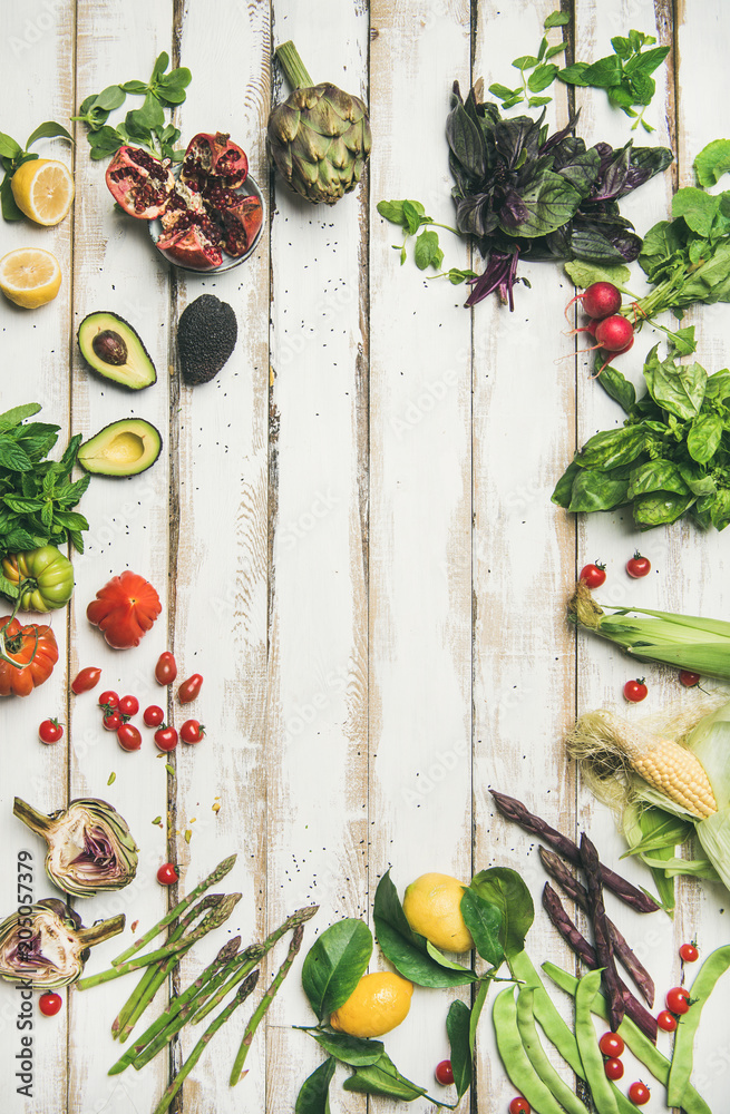 健康的生夏季纯素食食材。白色餐桌背面是五颜六色的蔬菜和绿色蔬菜