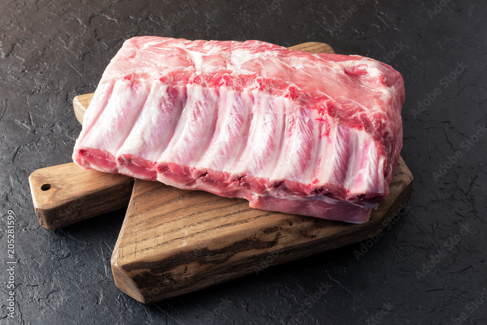 木板上的新鲜生猪肉块和乡村金属屠夫。美食摄影