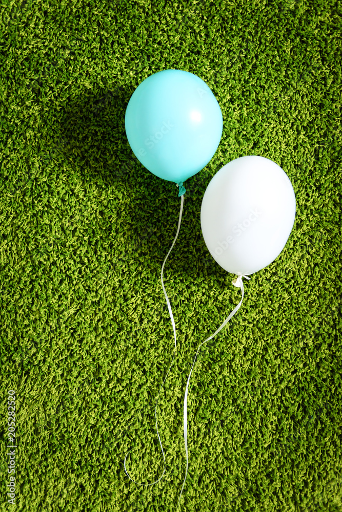 绿色地毯上的蓝白气球特写