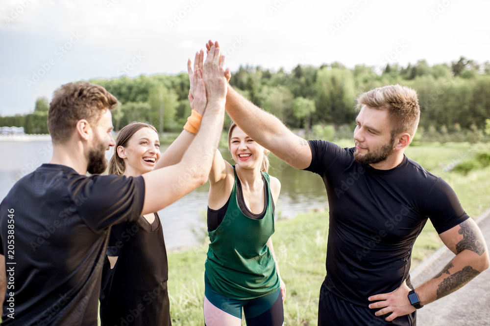 运动队在湖边公园进行户外训练后，双手合十，玩得很开心