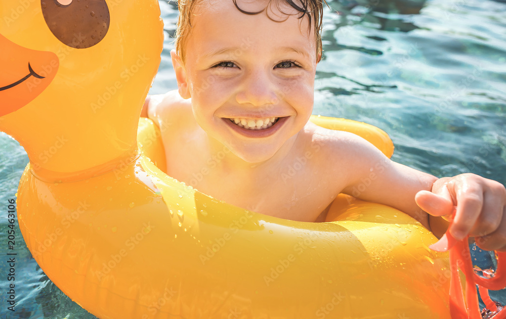 快乐男孩和游泳池里的黄色鸭子管