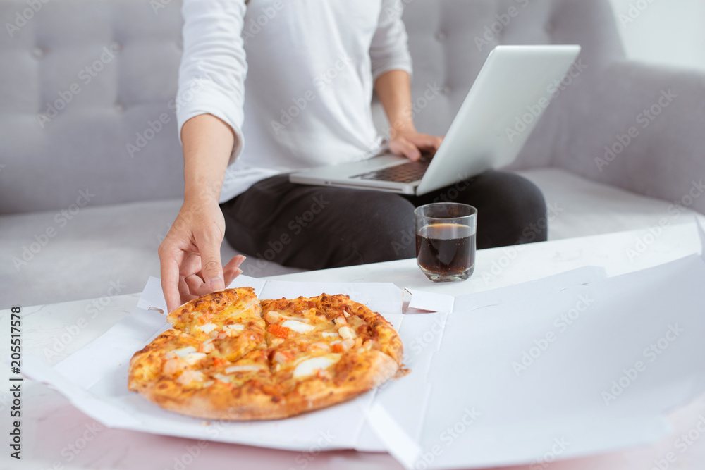 男人用笔记本电脑吃披萨
