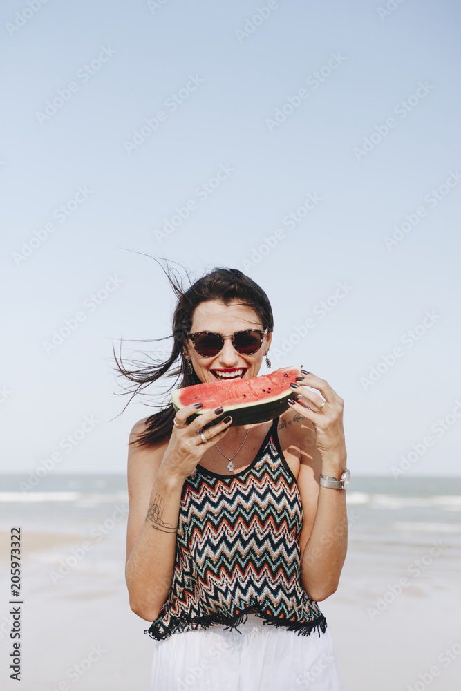 在海滩吃西瓜的女人