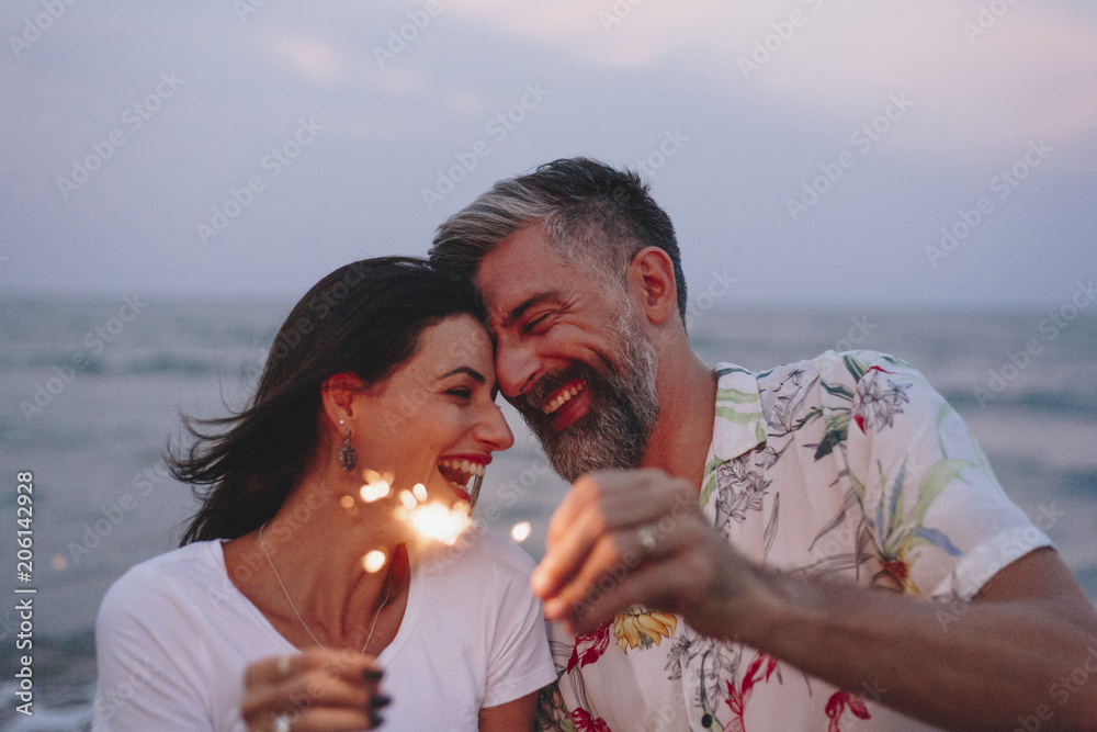 情侣在海滩上用火花庆祝