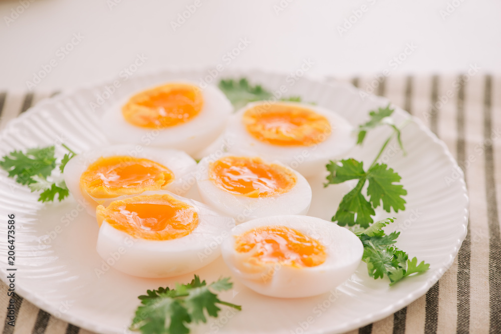 Close up medium soft boiled duck egg portion on white dish