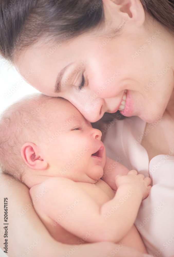 母亲和她的新生婴儿在一起。快乐的母亲和婴儿亲吻和拥抱。母性观念。