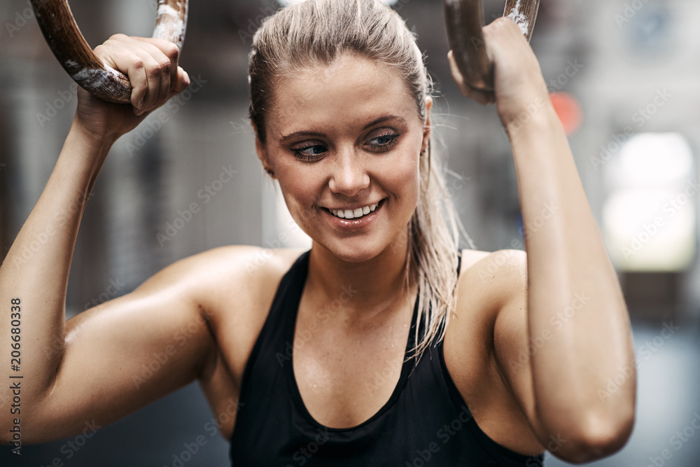 微笑的女人在健身房锻炼时戴着戒指锻炼