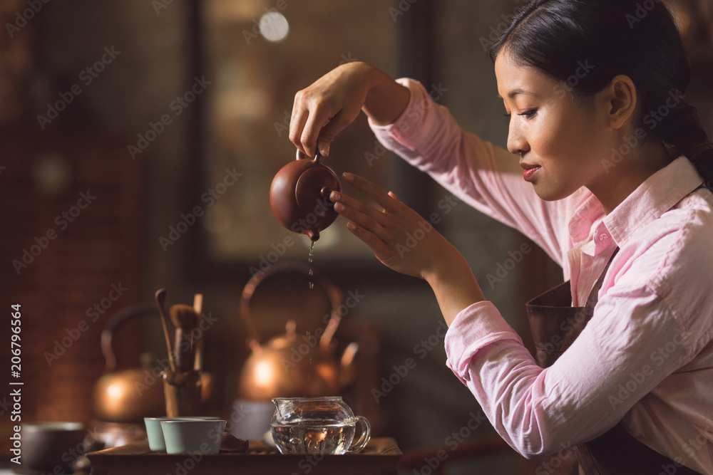 Young woman pouring tea
