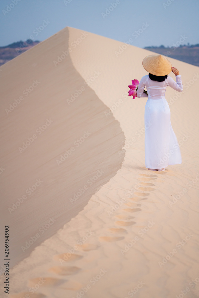 梅恩沙漠的沙滩上漫步的女士和荷花