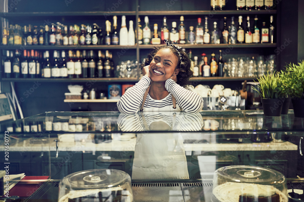 站在咖啡馆柜台后面微笑的非洲女人
