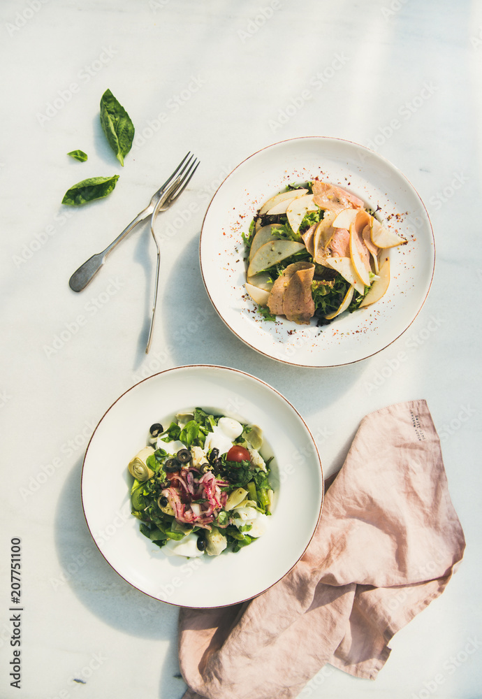 新鲜的绿色夏季沙拉，配洋蓟、橄榄、软奶酪、红洋葱和餐具