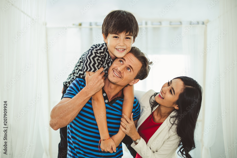 肖像快乐的家庭父亲，母亲和儿子，小男孩一起在卧室里玩耍