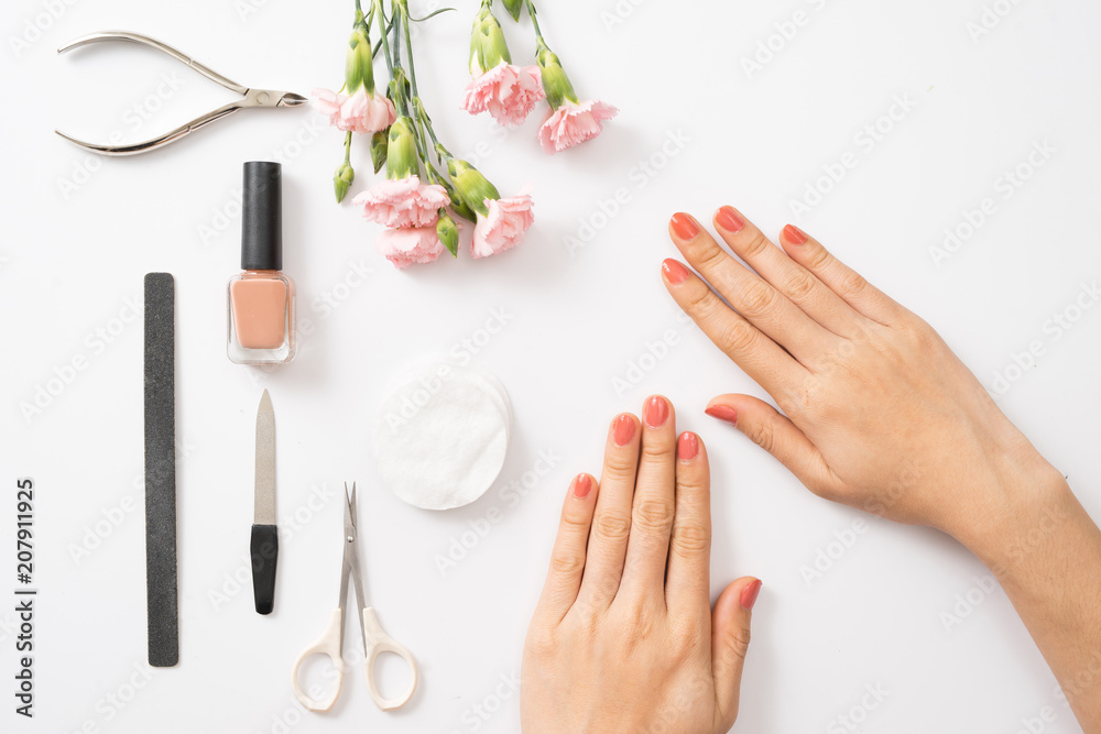 女性双手用毛巾和指甲在木桌上涂紫色指甲油