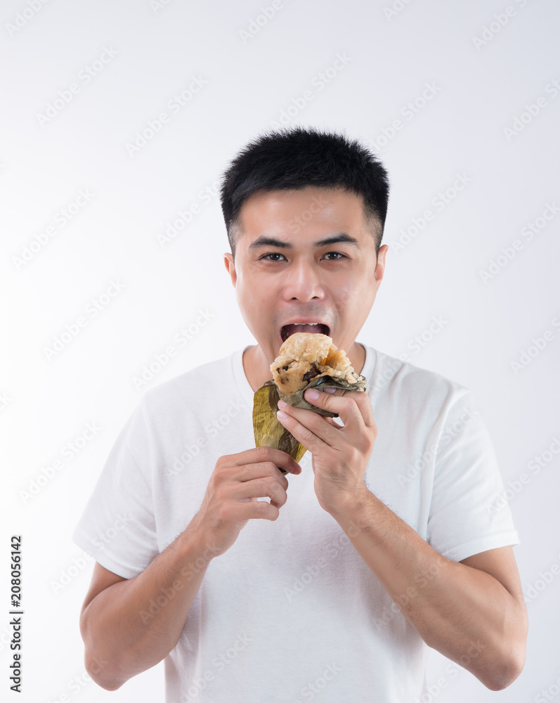 一名男子在端午节吃着美味的粽子（粽子），感觉很美味，亚洲tr