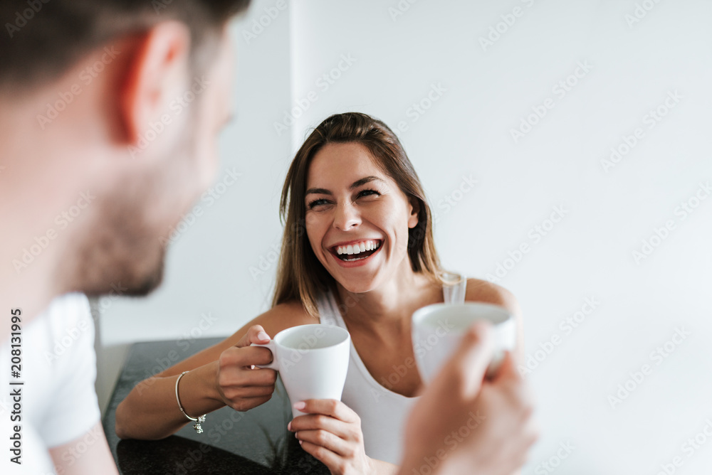 一对大笑的情侣早上喝咖啡。