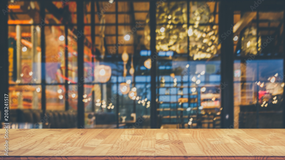 抽象模糊餐厅灯光背景前的木桌图像