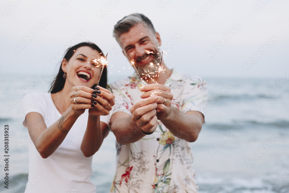 情侣在海滩上用焰火庆祝