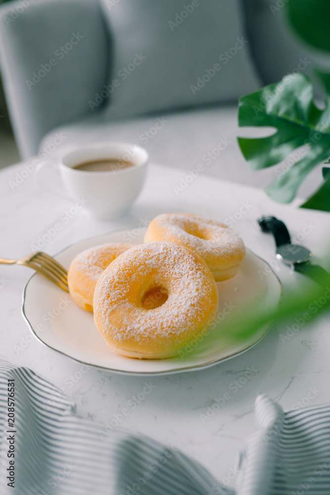 白色餐桌上的经典甜甜圈和咖啡。