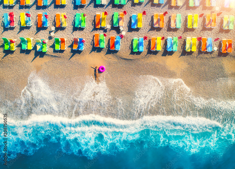 土耳其奥卢德尼兹，一位戴着游泳圈的躺在海里的女人的鸟瞰图。与年轻女孩的夏日场景