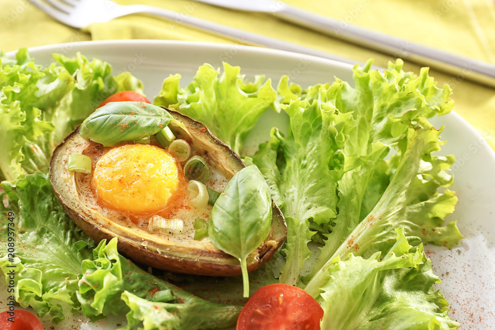 美味的烤鳄梨，盘子里有鸡蛋和新鲜蔬菜，特写
