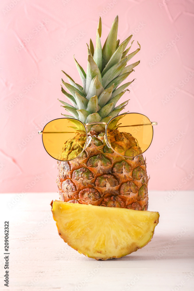 Delicious pineapple ad sunglasses on table