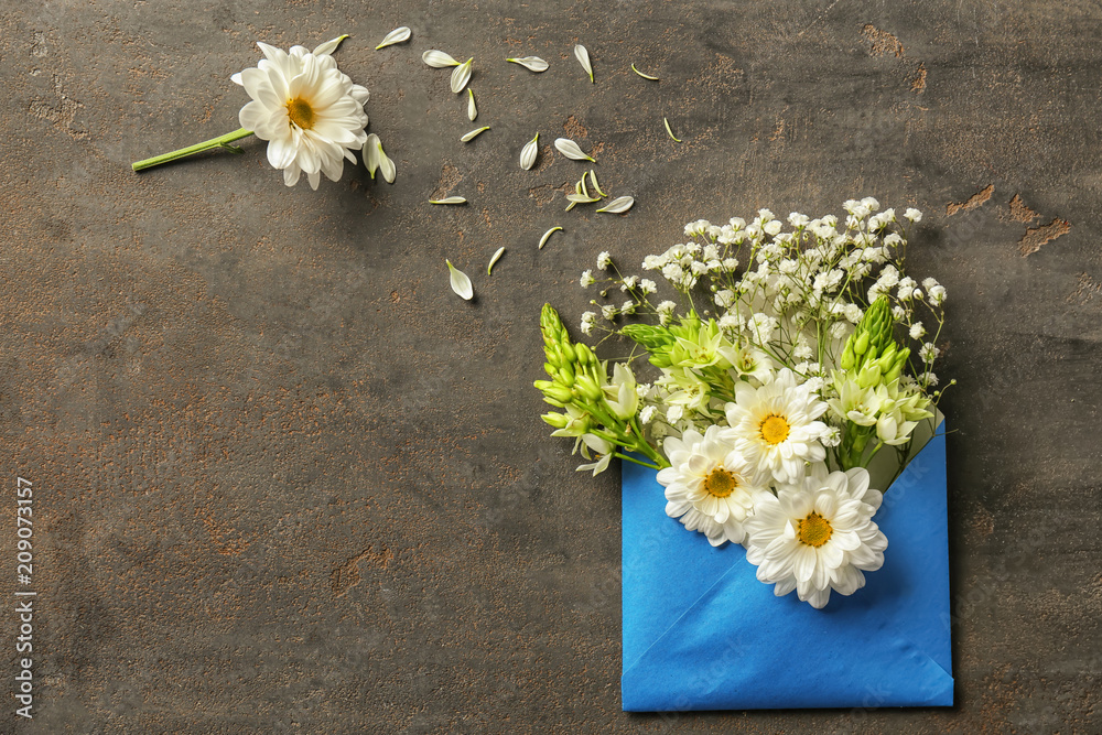 灰色纹理背景上有花朵的打开邮件信封
