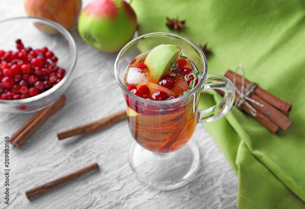木桌上的玻璃杯里装着苹果和蔓越莓的饮料