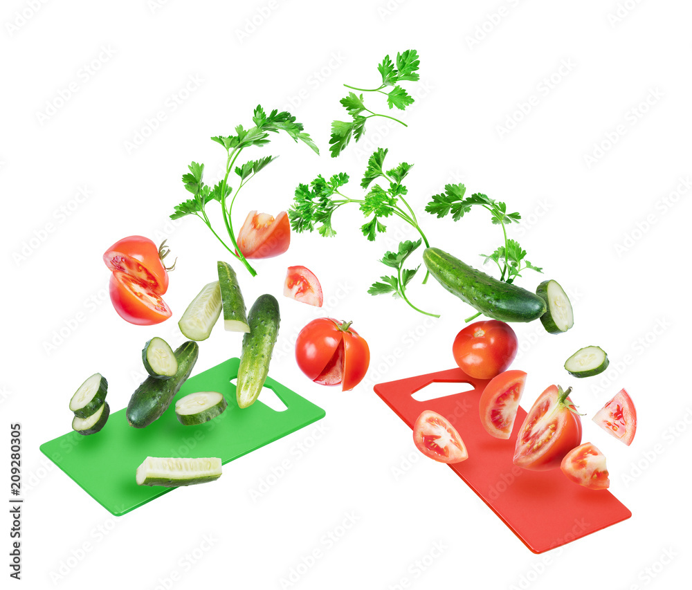 西红柿和黄瓜片配欧芹叶落在厨房的木板上