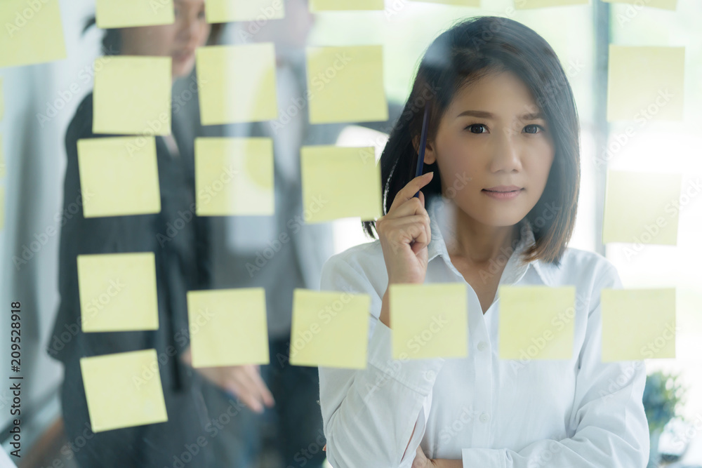 聪明而有策略的亚洲经理女性思维和在白人办公室工作的背景商业理念