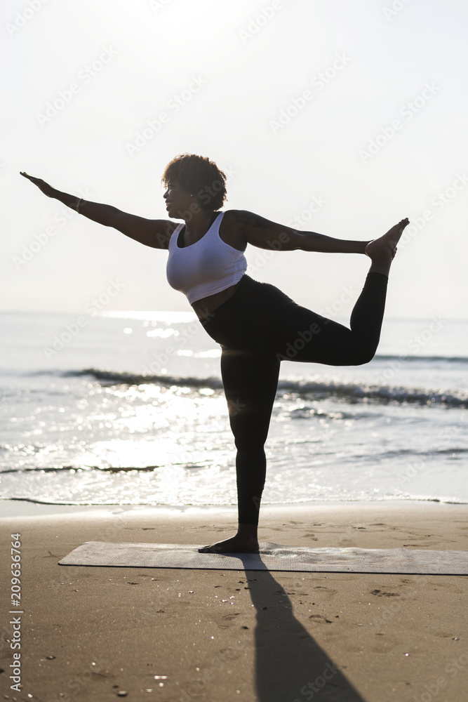 在海滩上练习瑜伽的非洲裔美国女性