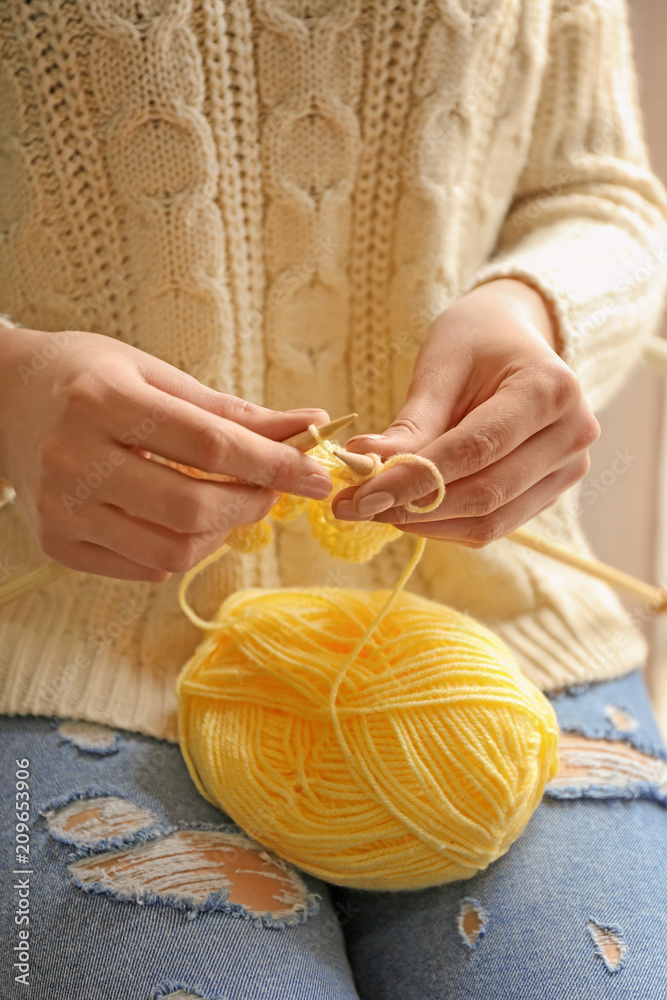 年轻女子在家编织衣服，特写