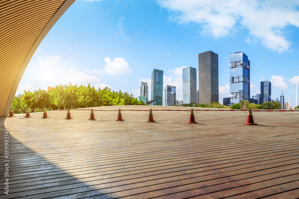 深圳日出时的木地板广场和现代城市商业建筑