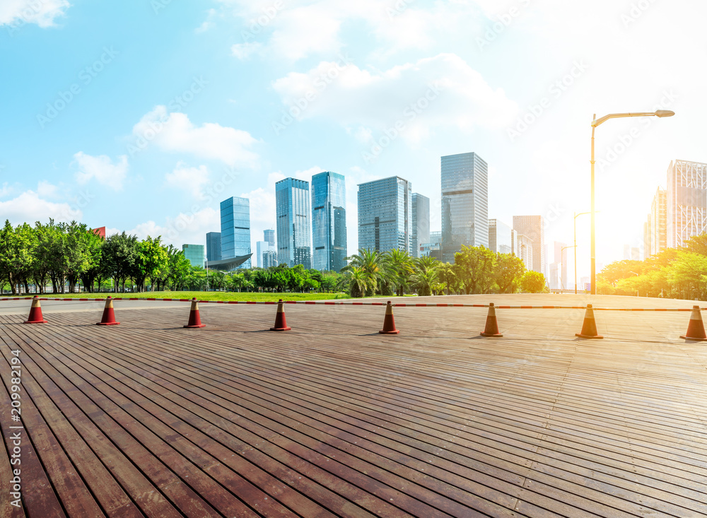 深圳日出时的木地板广场和现代城市商业建筑